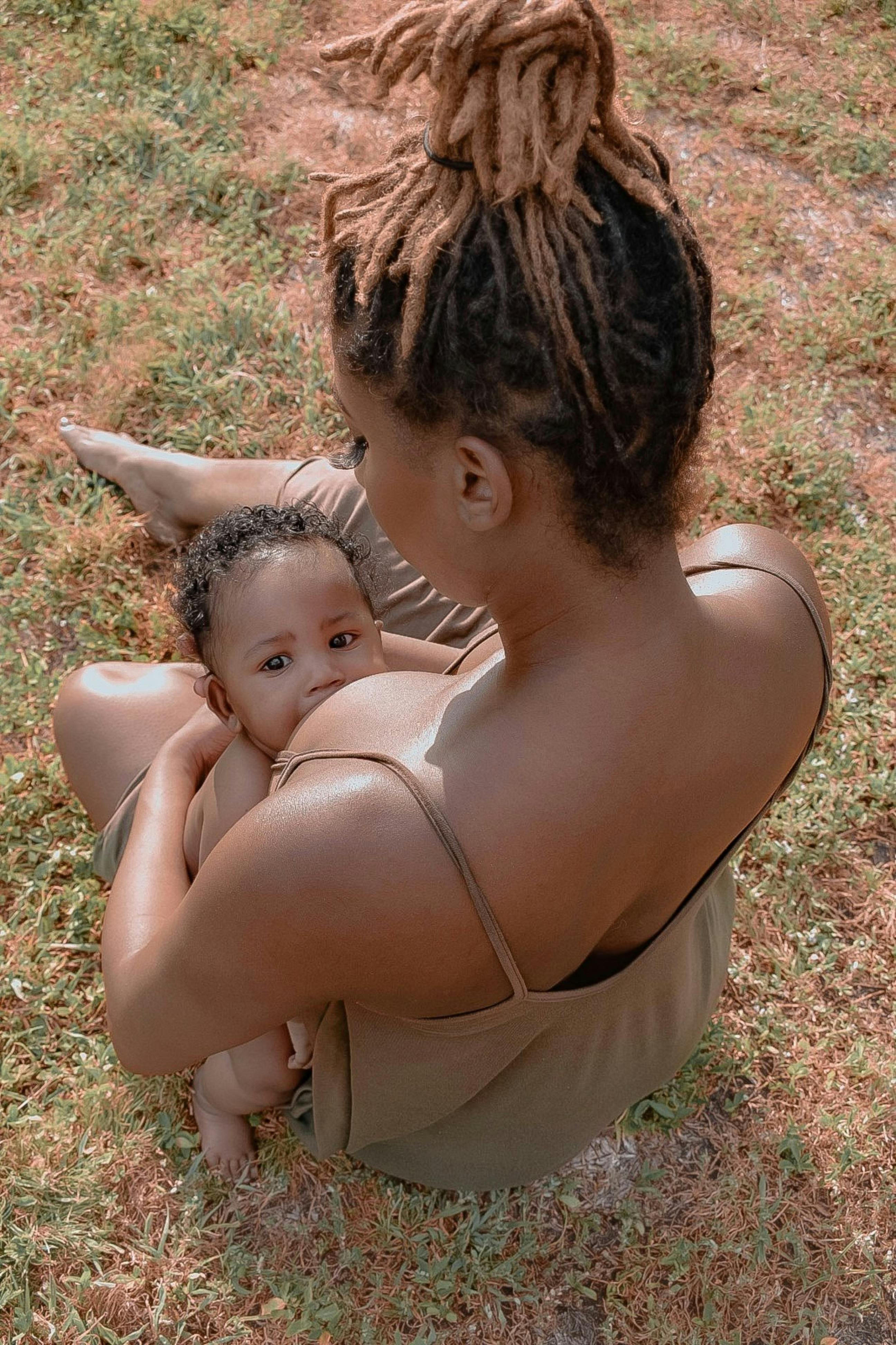 Black mother breastfeeding her newborn in intimate black and white portrait