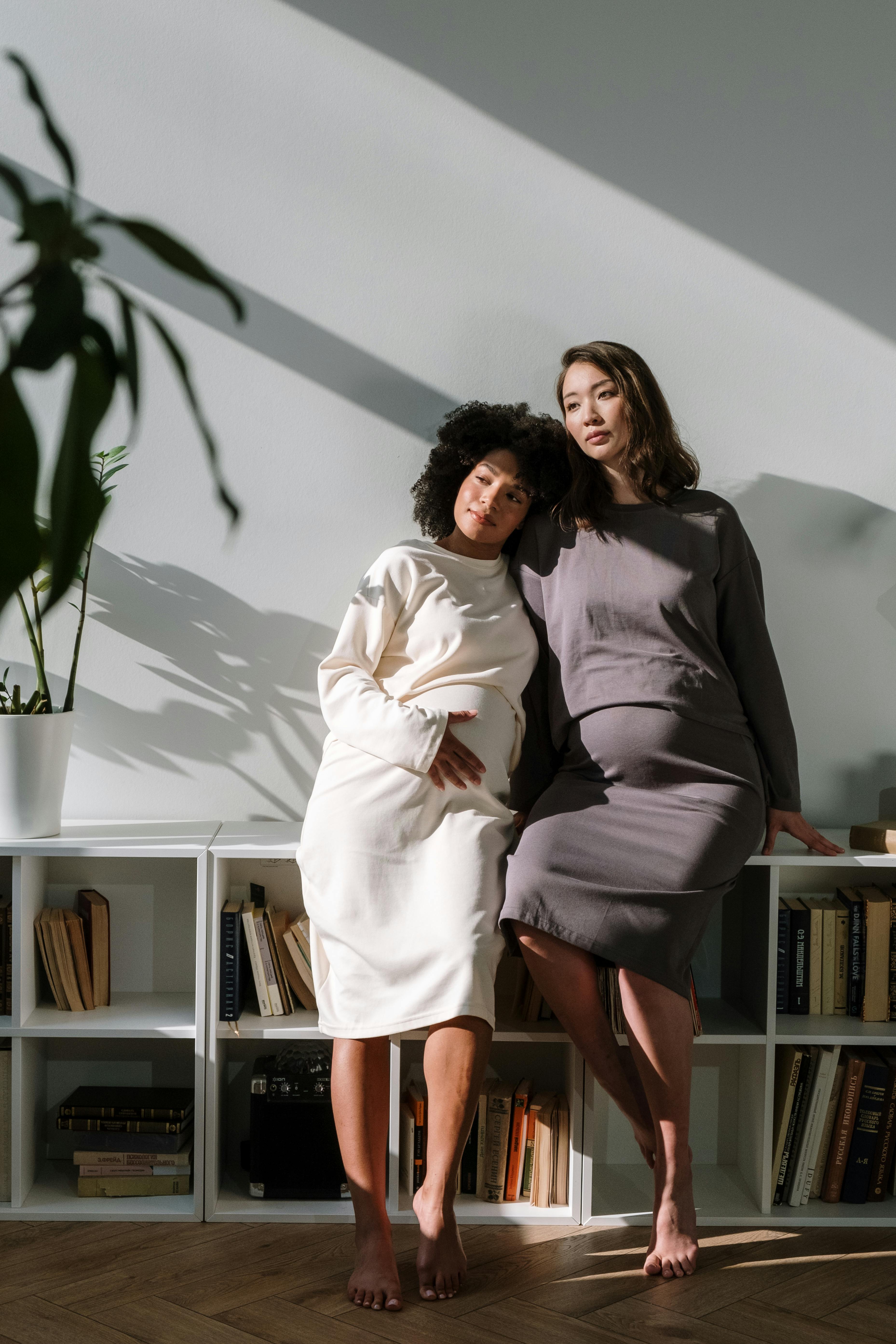 Two women leaning against one another, supported